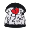 bonnet-de-ski-homme-noir-texte-graffiti-coeur-rouge Bonnet de ski pour homme noir avec un motif graffiti blanc et un cœur rouge central, idéal pour un look tendance et contrasté en hiver.