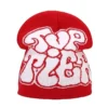 bonnet-de-ski-homme-rouge-texte-graffiti-urbain Bonnet de ski pour homme rouge avec un texte graffiti blanc au style urbain, parfait pour affirmer sa personnalité en montagne.