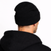 bonnet-noir-laine-hommes Un modèle porte un bonnet en laine noir de dos fond clair