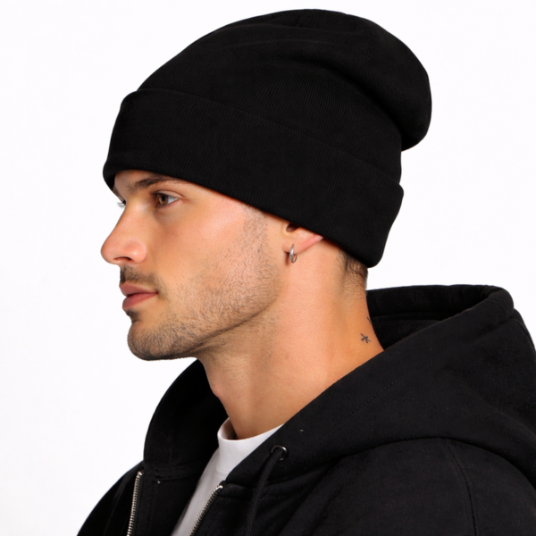 joli-bonnet-noir-leger-laine Un modèle porte un bonnet en laine noir de profil fond clair