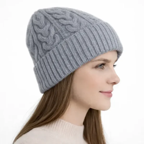 bonnet-femme-laine-gris-profil-torsades-epaisses Vue de profil d’un bonnet en laine gris pour femme, maille à grosses torsades et revers côtelé.
