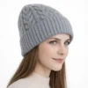 bonnet-hiver-femme-gris-maille-torsadee-vue-trois-quarts Bonnet d’hiver pour femme en laine grise, présenté en vue trois-quarts, avec tricot torsadé.