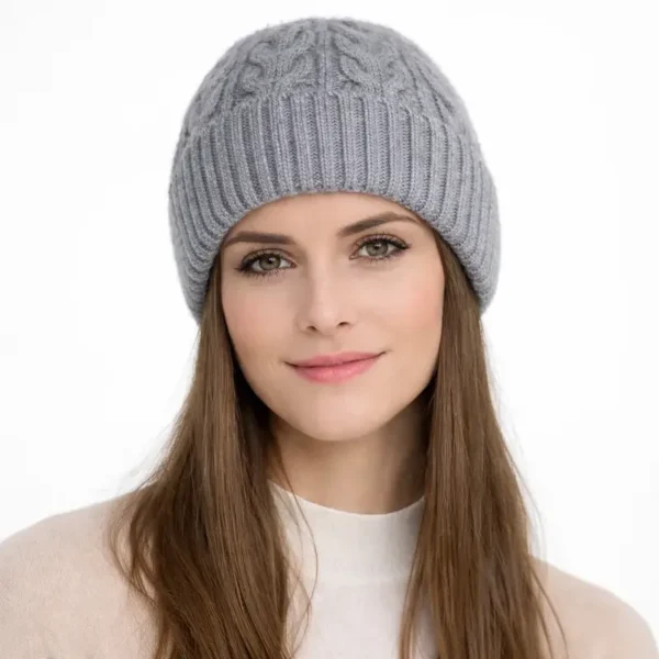 bonnet-tricote-pour-femme-gris-avec-revers-look-chic Femme portant un bonnet tricoté gris avec revers large, style chic et décontracté pour les jours froids.