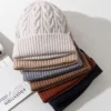 bonnets-femme-maille-epaissie-lot-couleurs-automne-hiver Pile de bonnets pour femme en maille épaisse, disponibles en plusieurs couleurs automne-hiver.