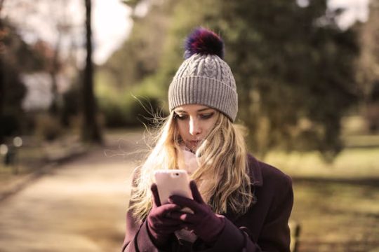 Une jeune femme en extérieur en automne porte un très joli bonnet en laine recyclée