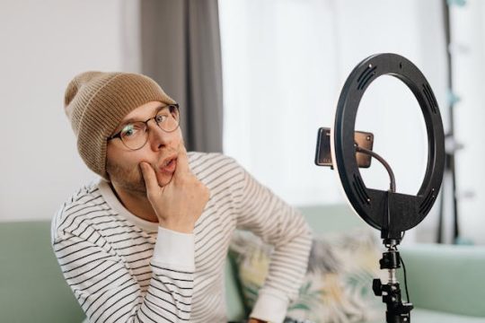Un homme à lunettes prend la pose avec un bonnet marron minimaliste dans son appartement