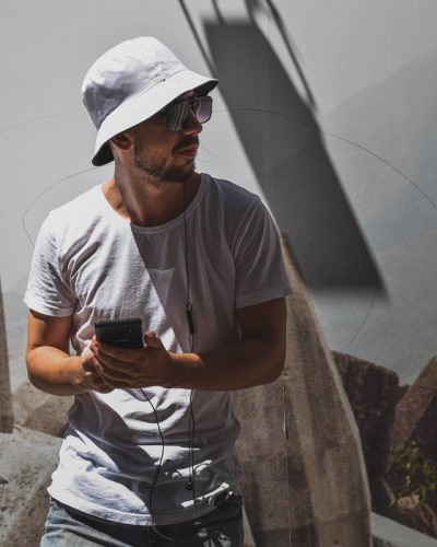 Un homme stylé et branché porte un bob chapeau et des lunettes